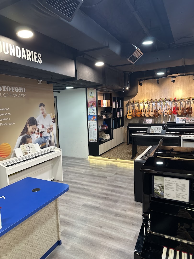 Interior view of Cristofori Music Experiential Center, showcasing pianos, ukuleles, and music lesson promotions.