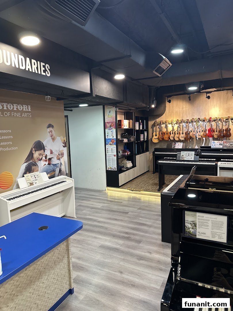 Interior view of Cristofori Music Experiential Center, showcasing pianos, ukuleles, and music lesson promotions.