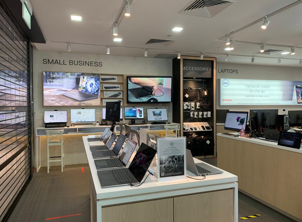 Interior view of a Dell Exclusive Store showcasing laptops, accessories, and display screens.