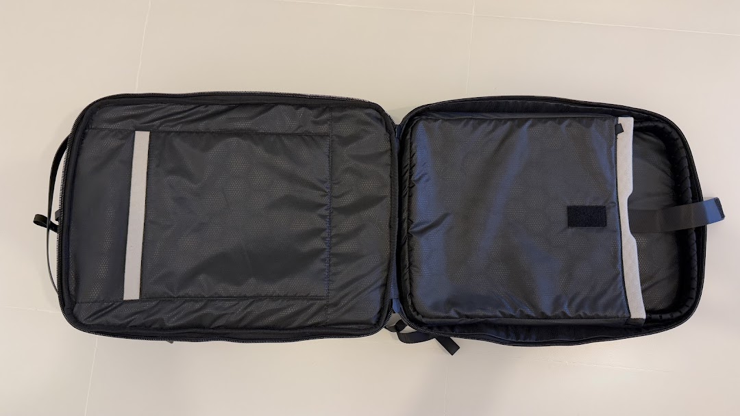 An open black laptop bag or case, revealing its padded interior compartments and organizational features.