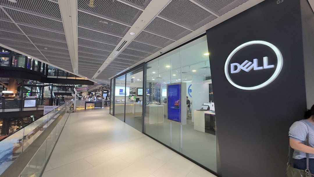 The image shows the exterior of a Dell Exclusive Store with its prominent logo and glass facade.