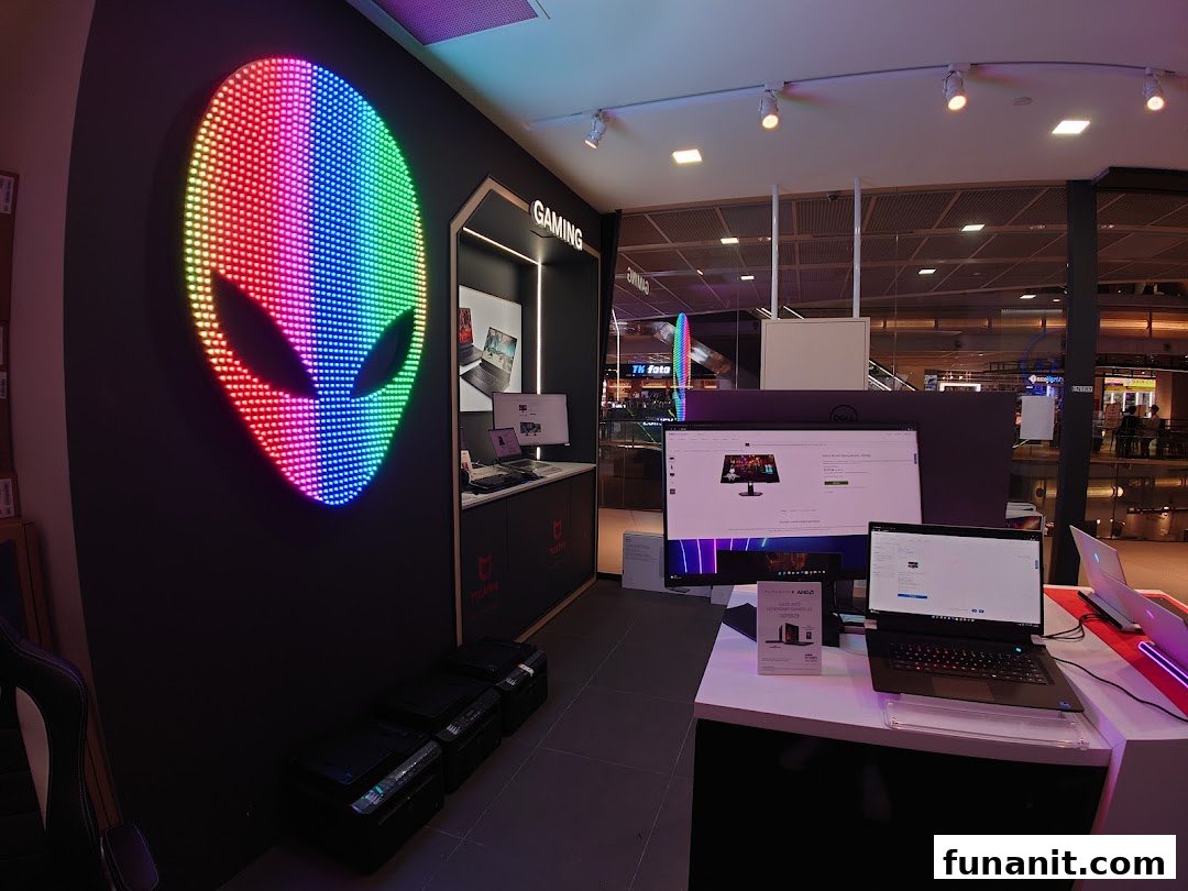 An Alienware gaming display inside a Dell Exclusive Store, featuring a vibrant LED alien head logo and gaming setups.