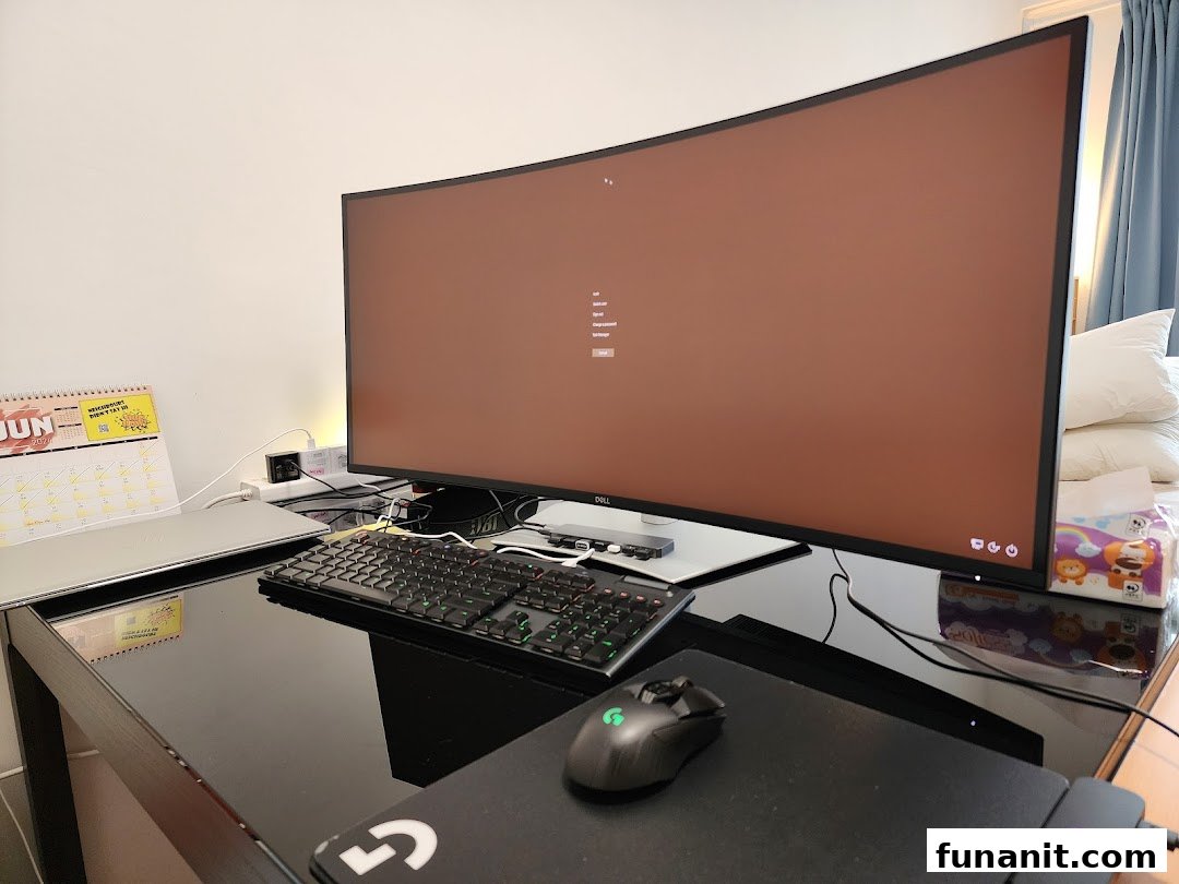 A large curved Dell monitor, keyboard, and mouse on a desk, showcasing a modern computing setup.