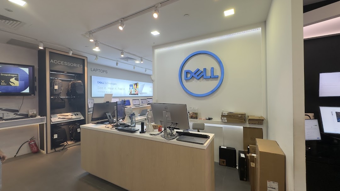 Interior view of a Dell Exclusive Store, showcasing laptops, accessories, and the prominent Dell logo.