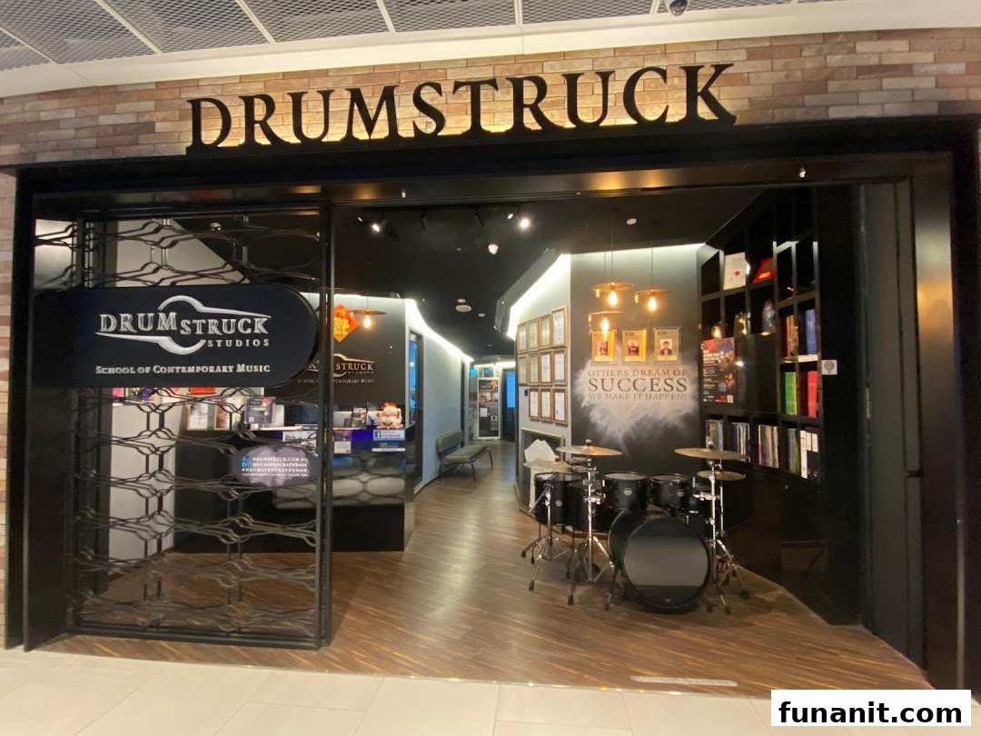 The shop front of Drumstruck Studios, a music school, featuring a drum set inside.