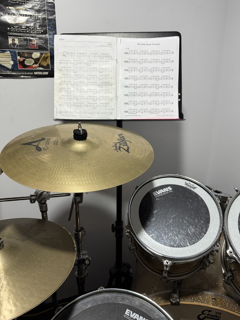 A drum set with cymbals and sheet music on a stand, ready for practice.