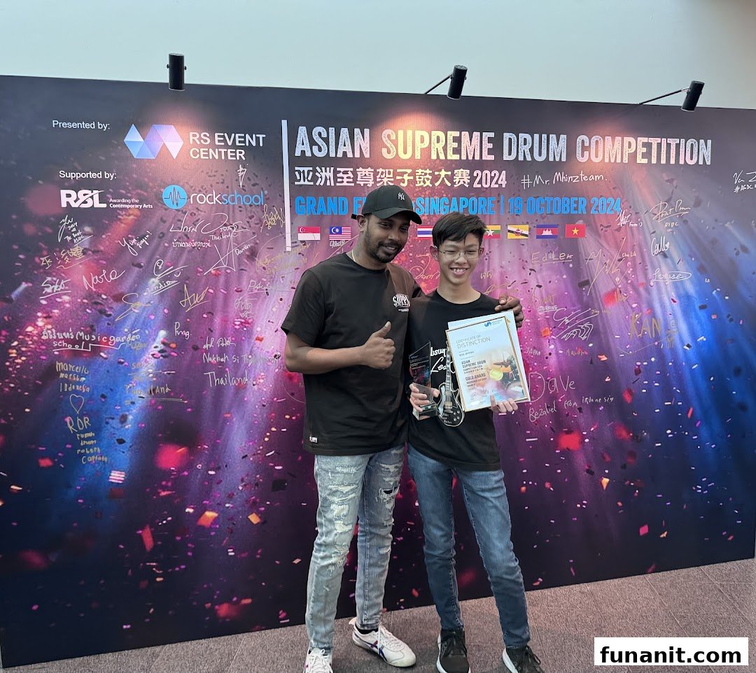 Two individuals celebrate an award at the Asian Supreme Drum Competition, showcasing drumming excellence.