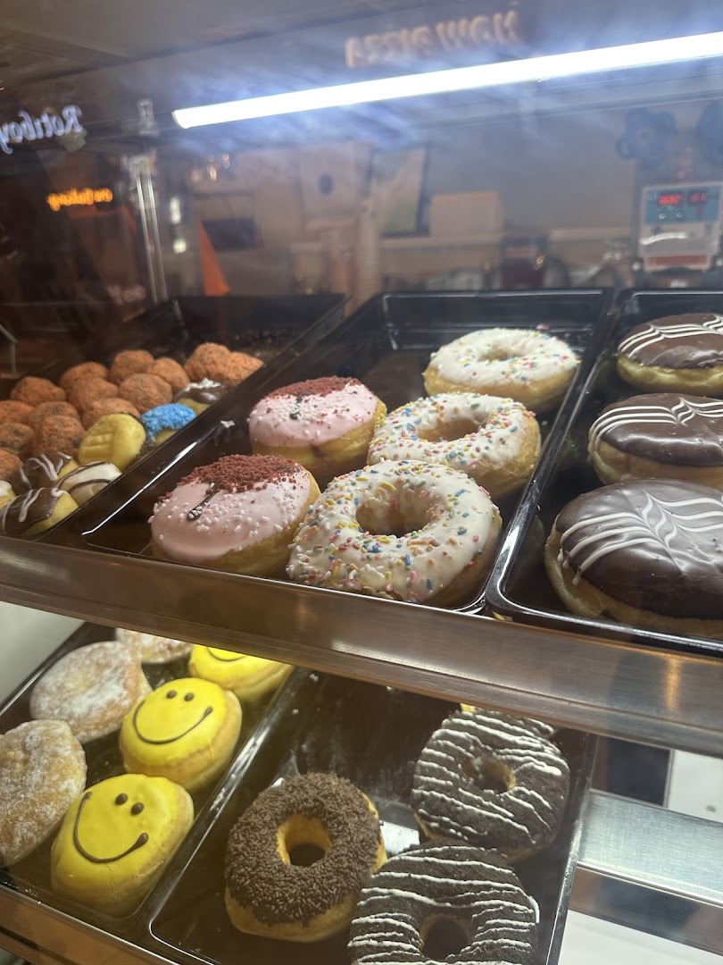 A vibrant display case showcasing a variety of freshly baked donuts with different toppings and glazes.