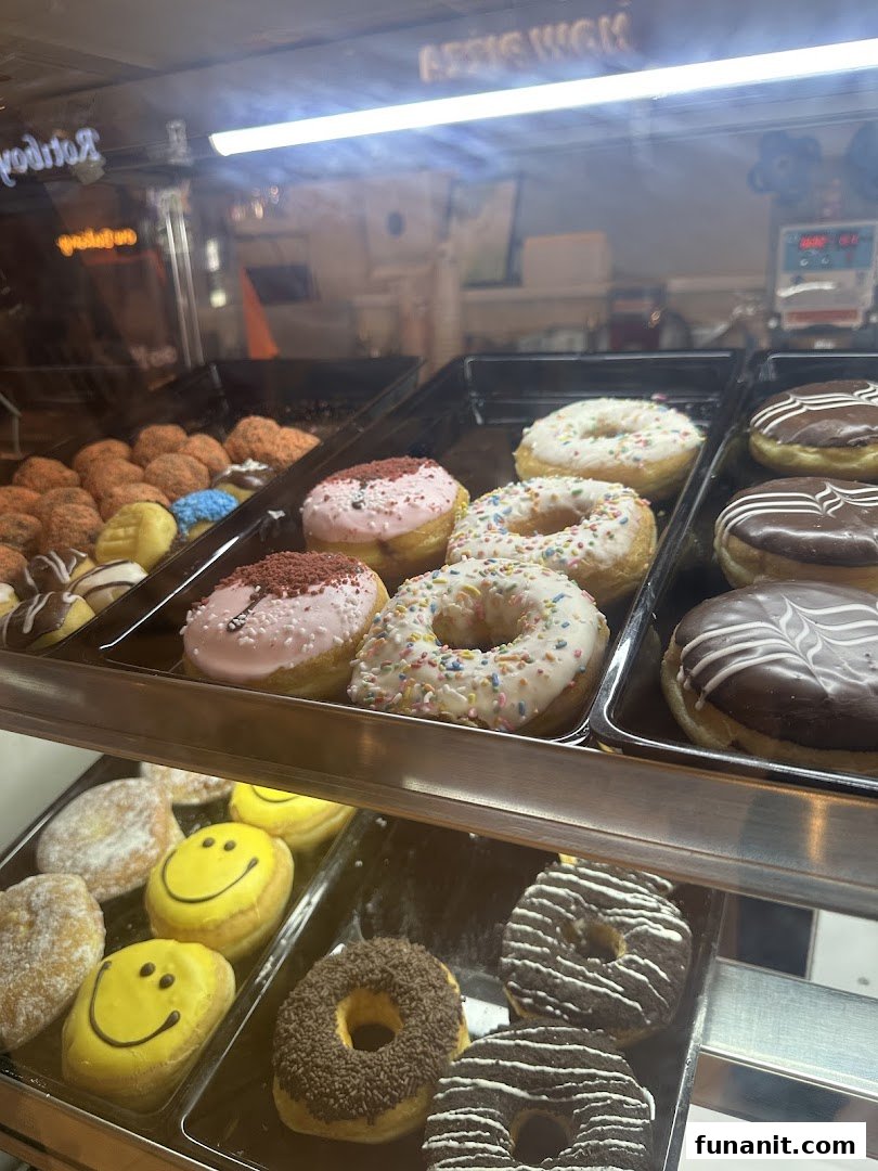 A vibrant display case showcasing a variety of freshly baked donuts with different toppings and glazes.