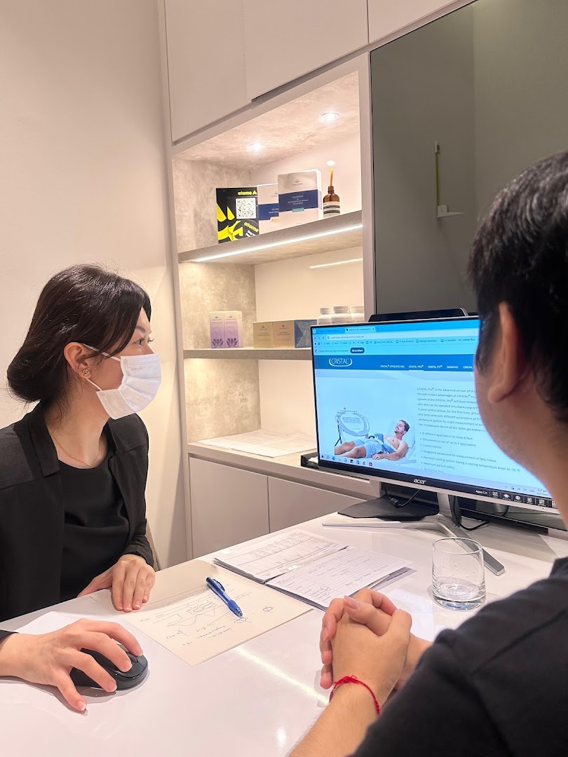 A staff member consults a client at a desk, with wellness products displayed in the background.