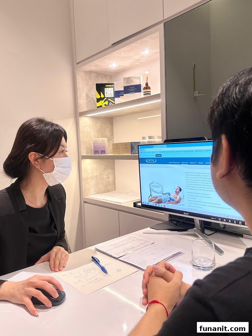 A staff member consults a client at a desk, with wellness products displayed in the background.