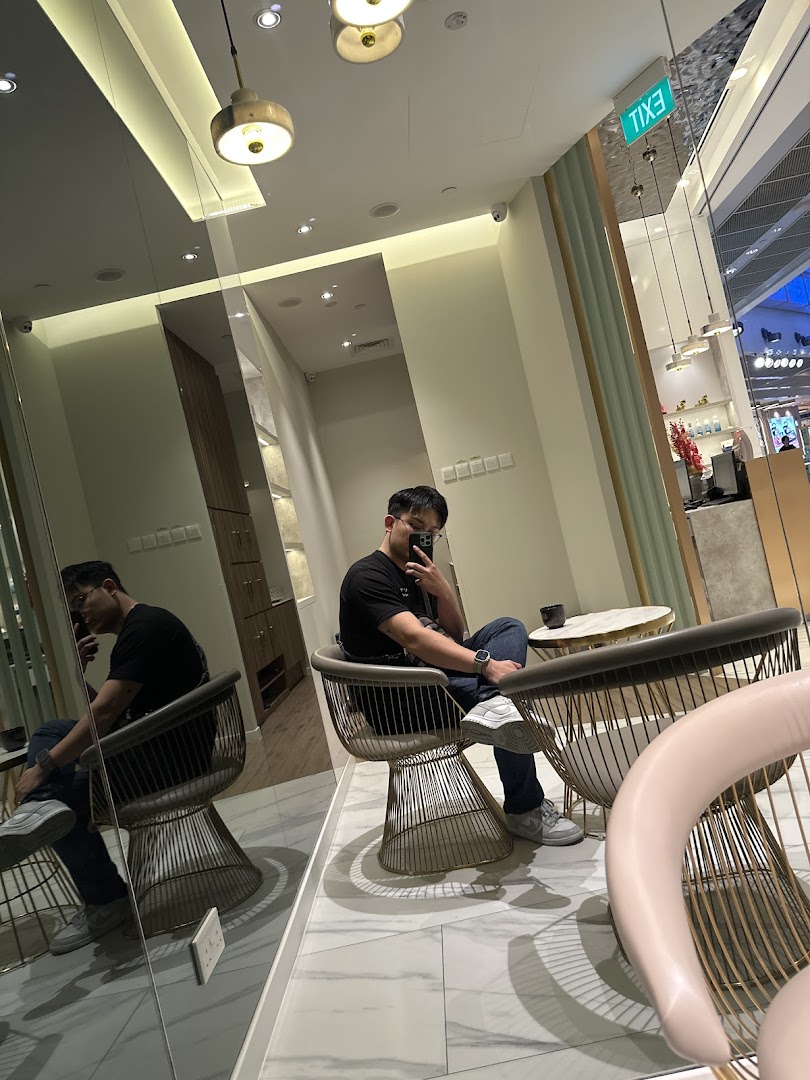 Interior shot of a modern salon or clinic waiting area with a person seated.