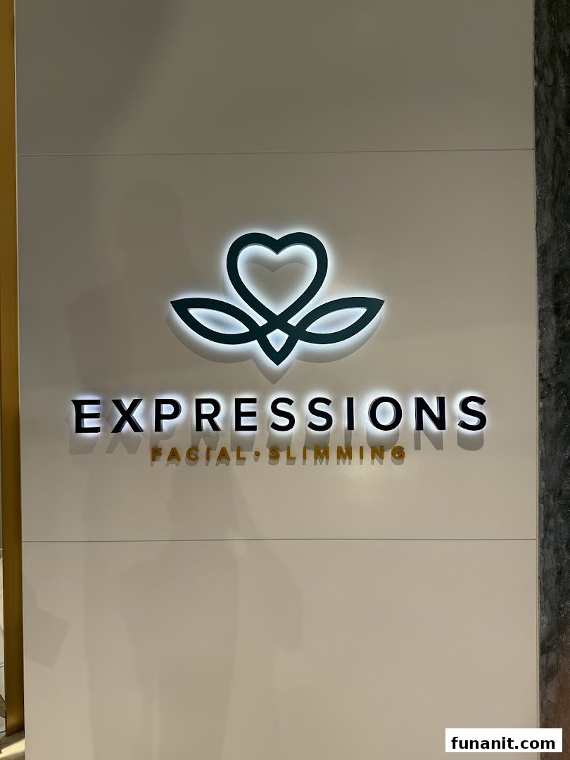 Close-up of the Expressions shop logo and name on a white wall.