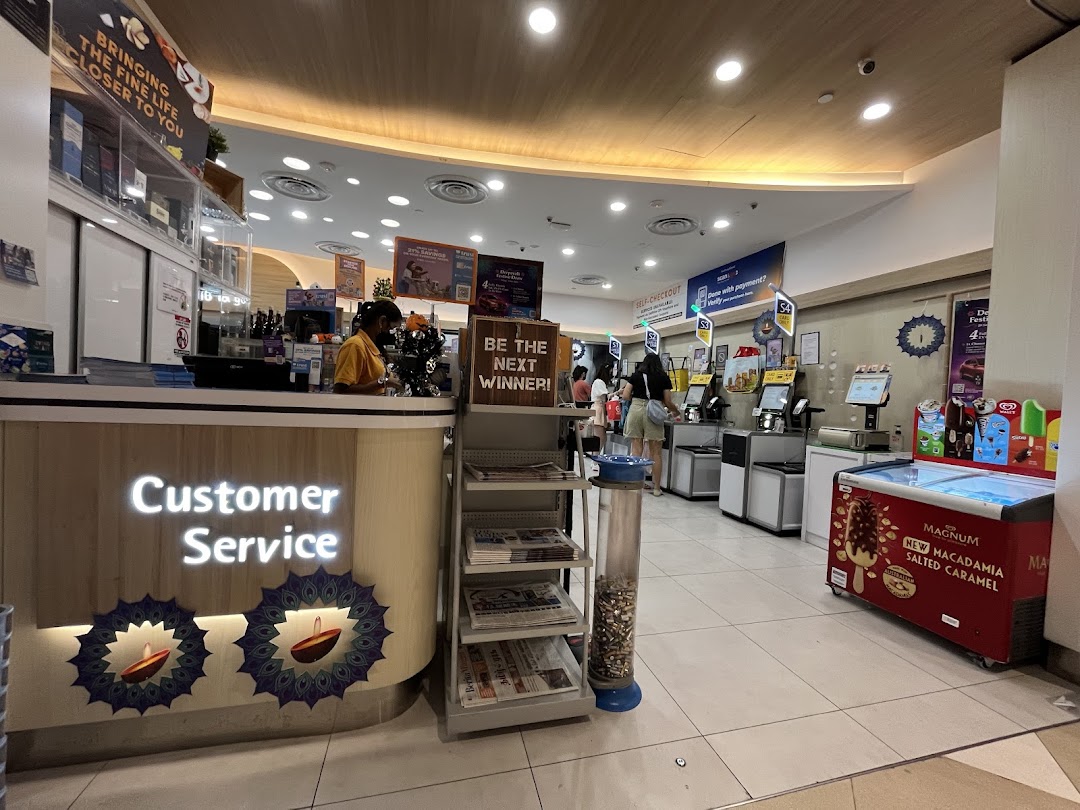 Interior view of FairPrice Finest, showcasing the customer service desk and self-checkout counters.