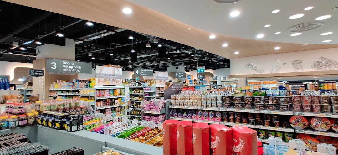 An interior view of FairPrice Finest supermarket, showcasing well-stocked aisles with groceries and clear signage.