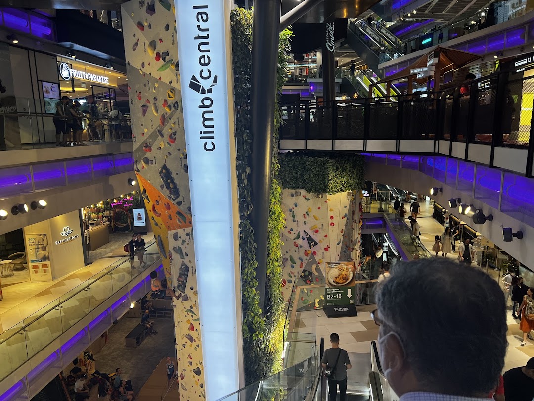 Vibrant multi-level mall interior featuring a prominent indoor climbing wall and various retail outlets.