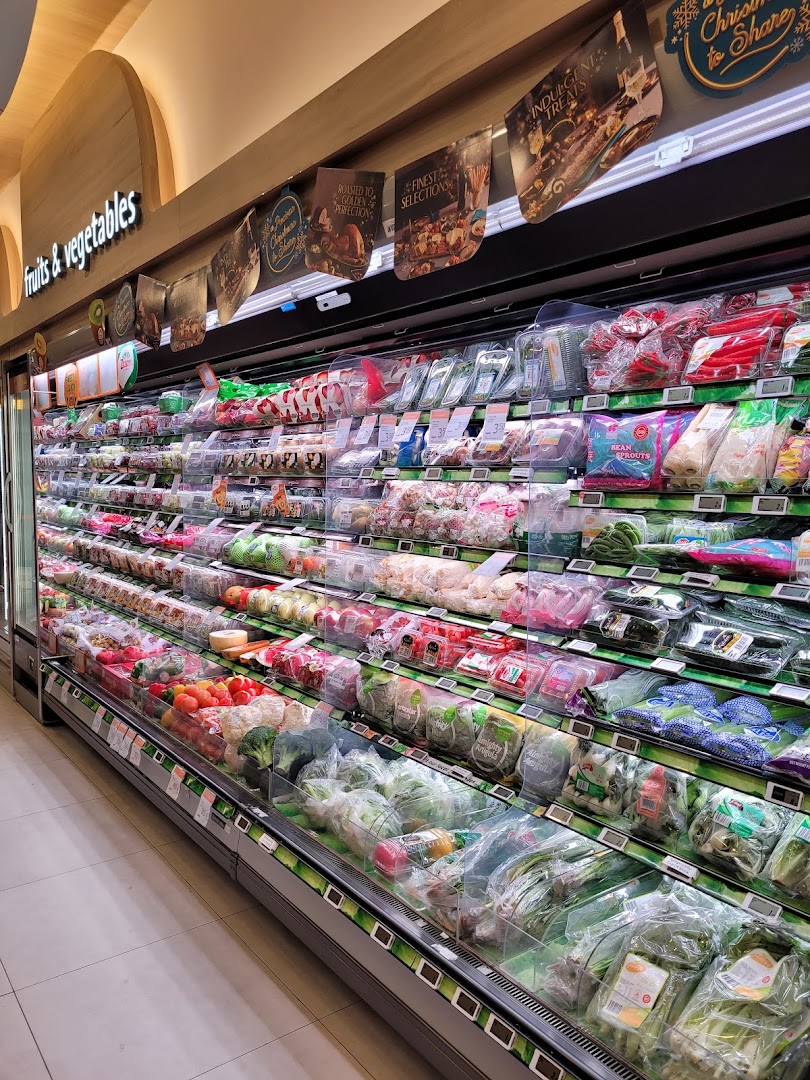 A vibrant display of fresh fruits and vegetables in a well-stocked supermarket aisle.