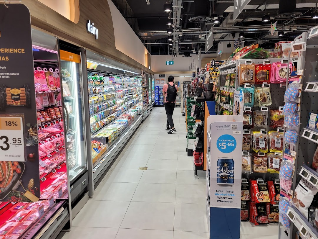 Interior view of FairPrice Finest supermarket with refrigerated aisles and various products.