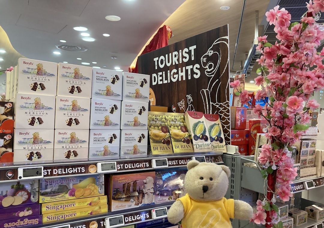 An aisle at FairPrice Finest featuring 'Tourist Delights' with Singapore-themed chocolates and snacks.