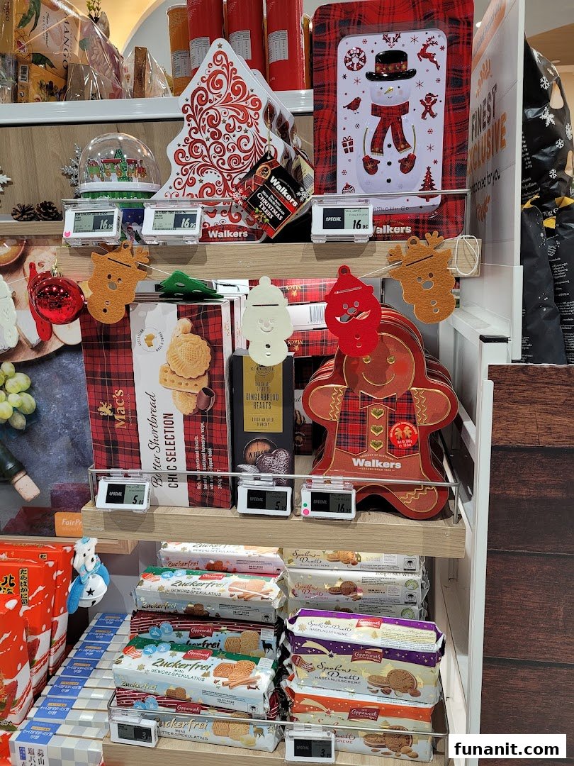 A festive retail display at FairPrice Finest featuring Christmas-themed biscuits, decorative tins, and holiday treats.