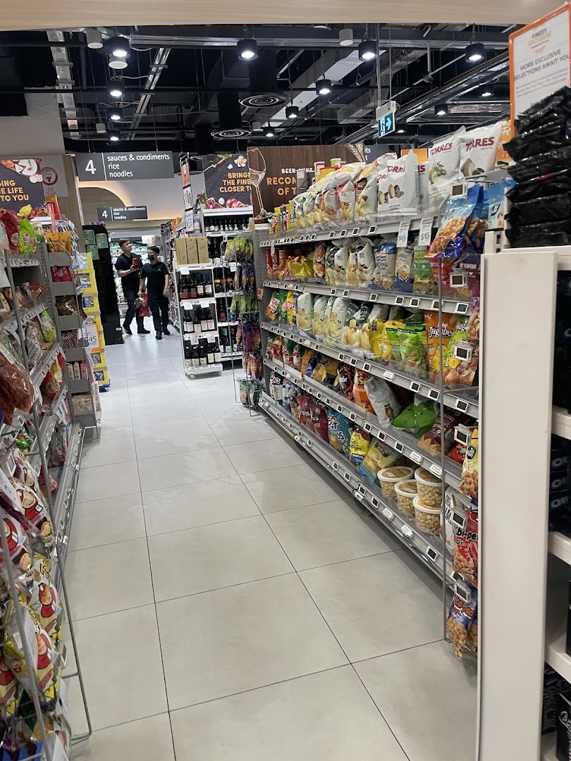A well-stocked aisle at FairPrice Finest Funan Mall, featuring a variety of snacks and groceries.