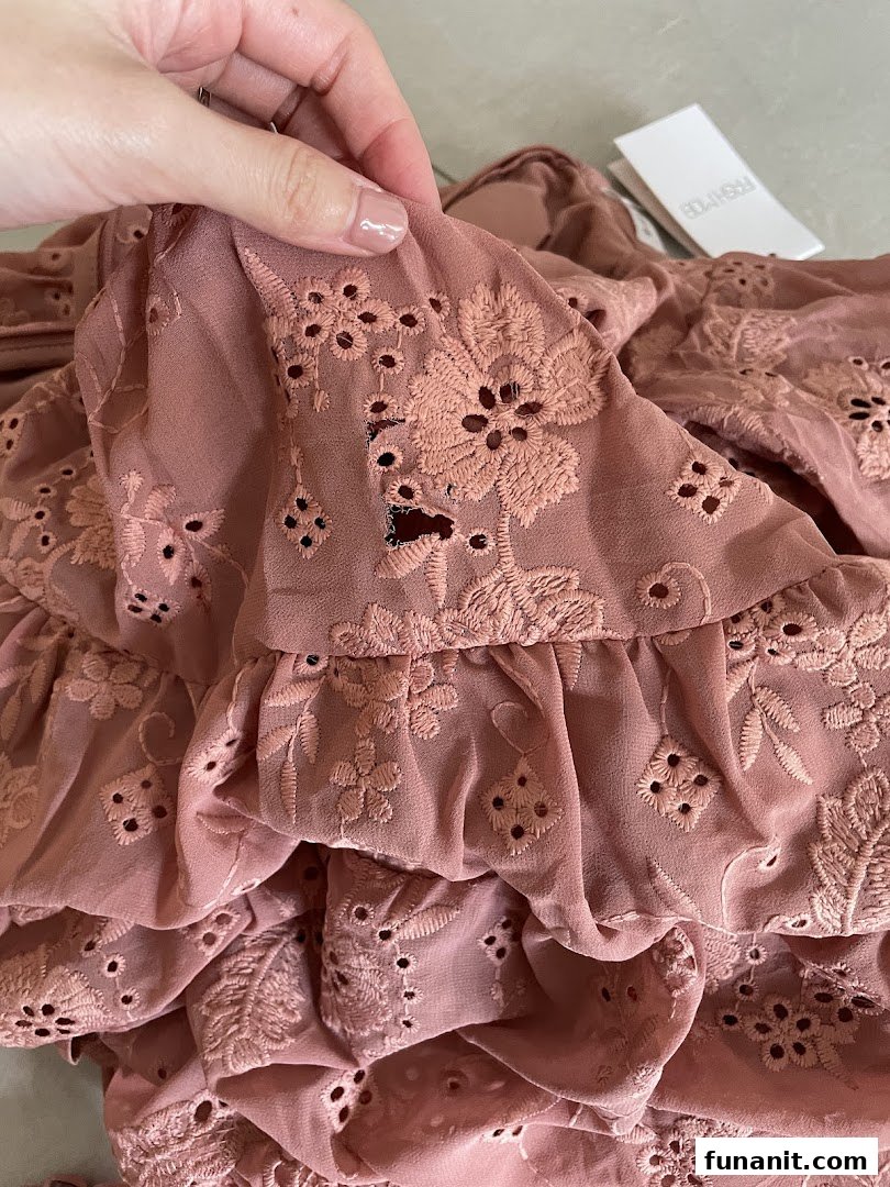 Close-up of a dusty rose fabric with intricate eyelet embroidery and ruffles, showcasing Fash Mob's design.