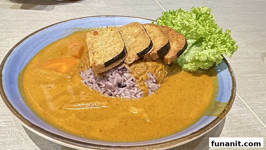 A vibrant plate of curry with purple rice, tofu slices, and fresh lettuce.