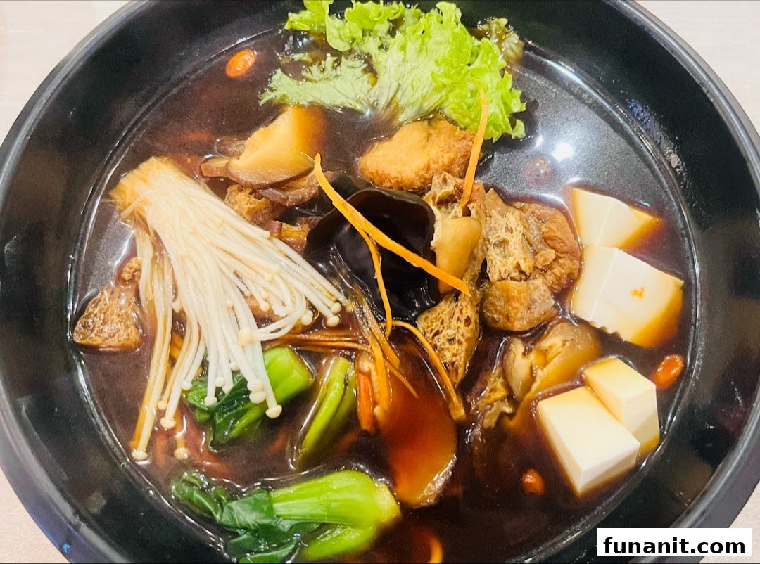 A close-up of a hearty, dark broth soup filled with mushrooms, tofu, and green vegetables in a black bowl.