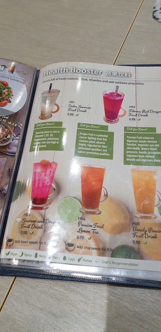 A close-up of a menu page featuring 'Health Booster' fruit drinks with descriptions and prices.