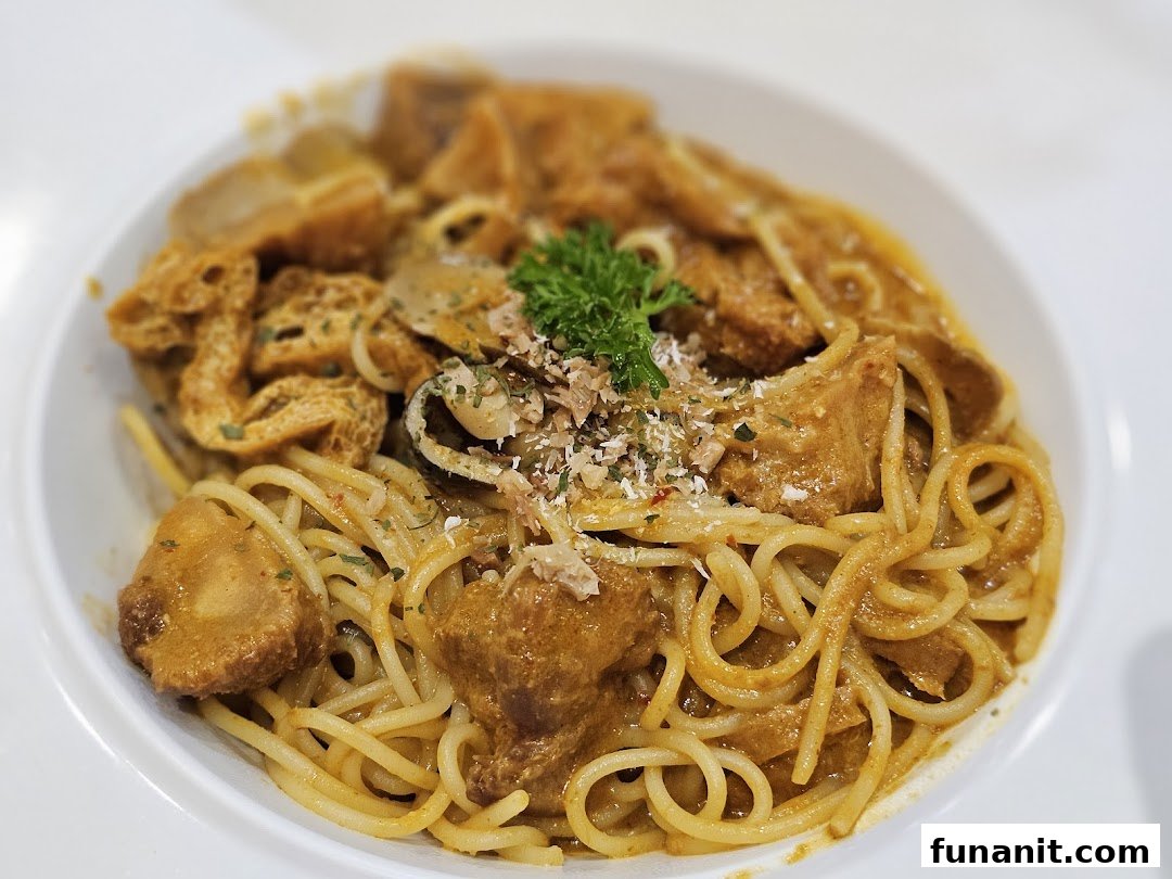 A close-up of a delicious pasta dish with a rich, creamy sauce, topped with tofu puffs and herbs.