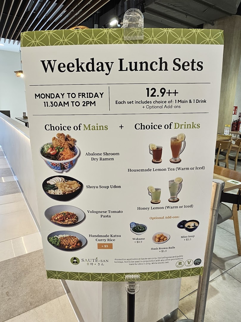 A large sign displaying the Weekday Lunch Sets menu for Flavours by Saute, featuring mains, drinks, and add-ons.