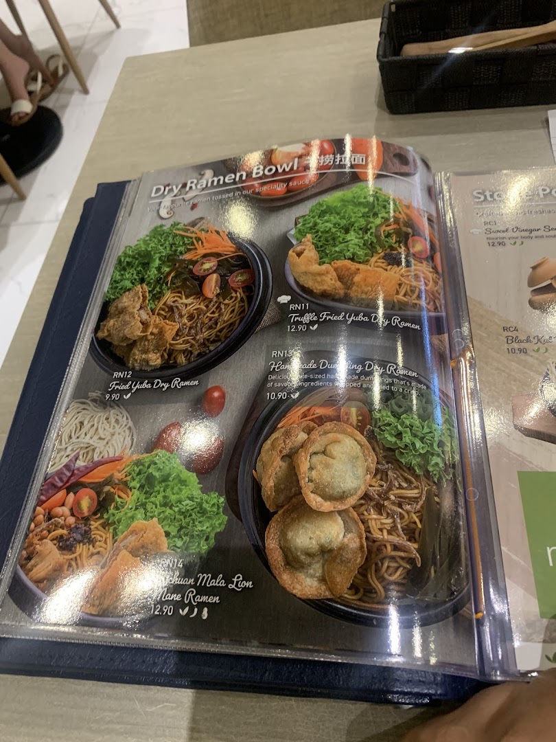 A close-up view of a menu page featuring various dry ramen bowl dishes with images and prices.