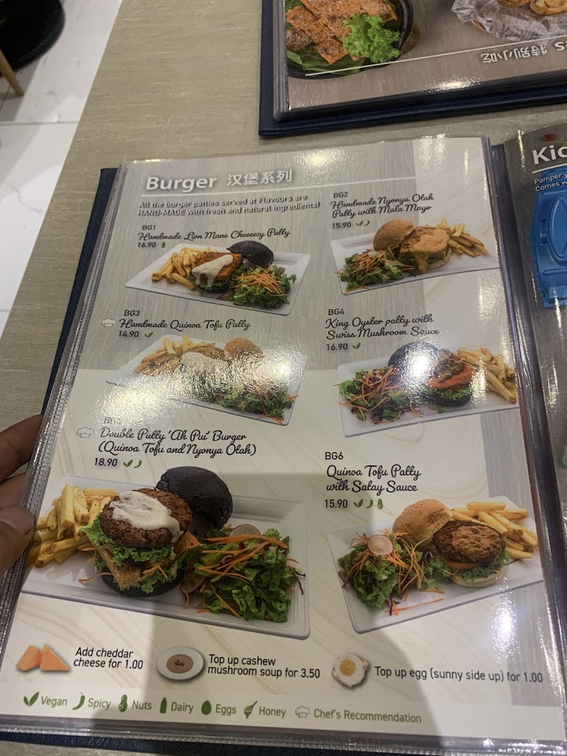 A menu page from Flavours by Saute, showcasing a variety of handmade vegetarian and vegan burgers.