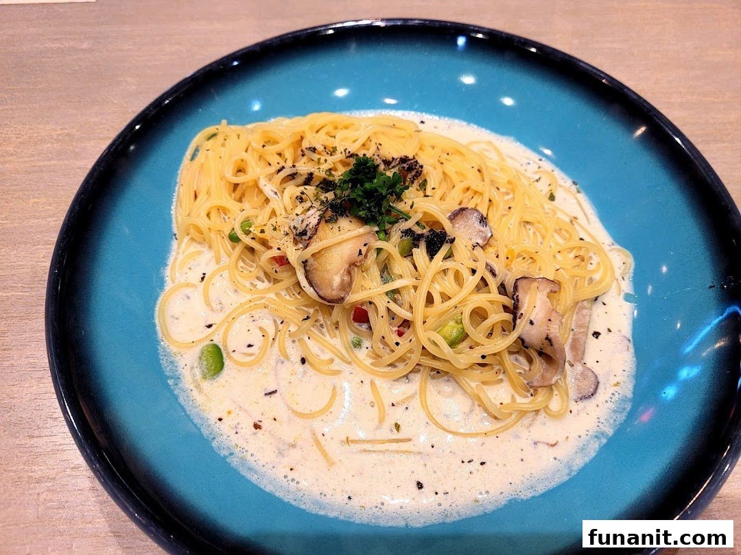 A close-up of creamy pasta with mushrooms, peas, and herbs on a vibrant blue plate.