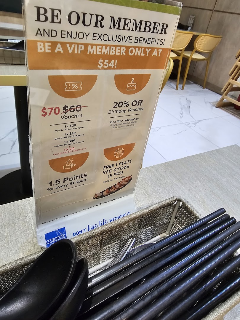 A close-up of a membership benefits standee on a dining table, featuring exclusive offers.