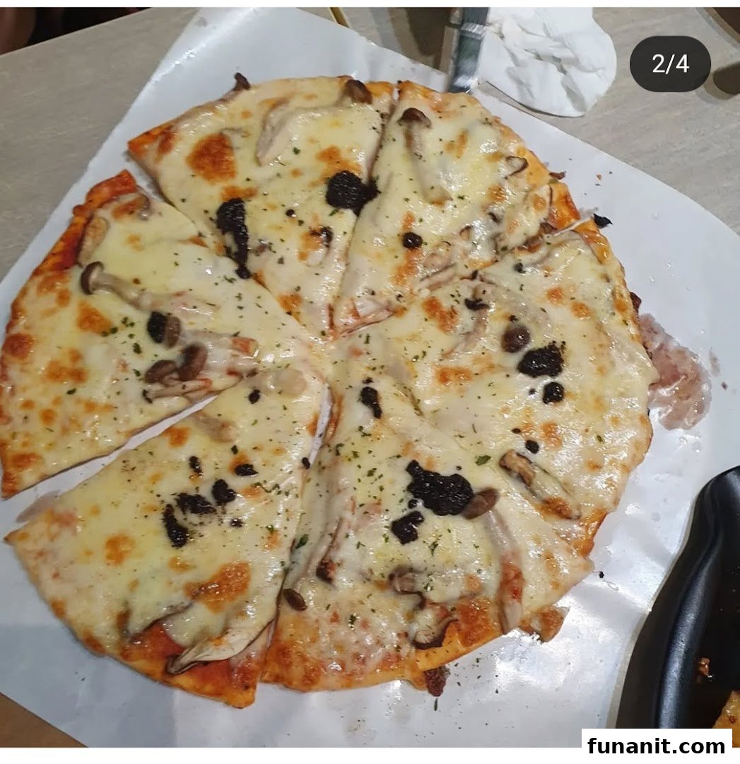 A delicious mushroom and cheese pizza with truffle shavings, served on white paper.