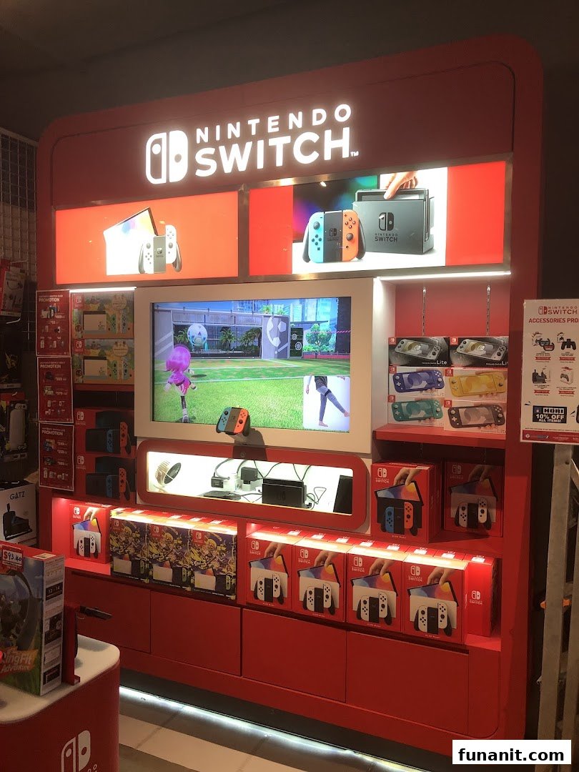 A vibrant red Nintendo Switch display showcasing consoles, games, and accessories in a retail store.