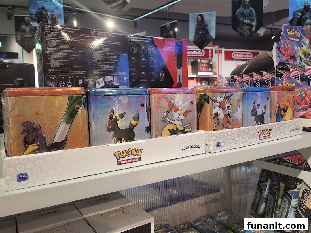 A shelf displays various Pokémon Trading Card Game tins and other gaming merchandise inside GameMartz.