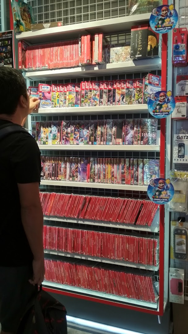 A customer browses a large selection of Nintendo Switch games and accessories at GameMartz Funan Mall.