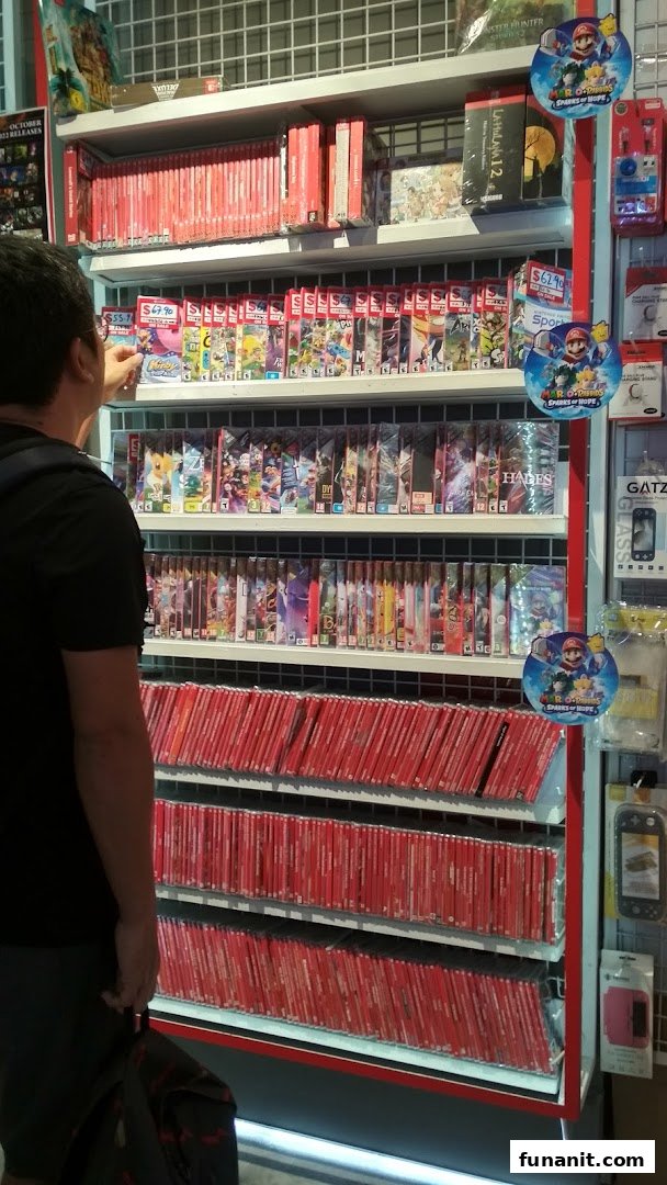 A customer browses a large selection of Nintendo Switch games and accessories at GameMartz Funan Mall.