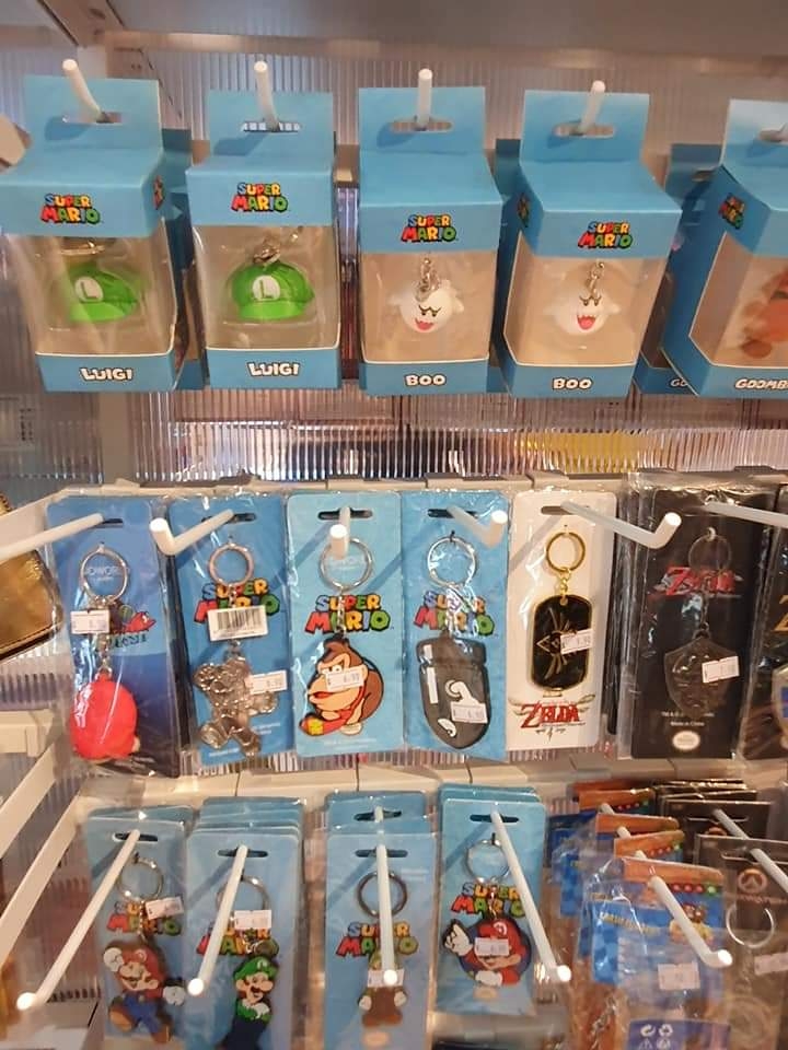 A display of Super Mario and Zelda themed keychains and small figures for sale.