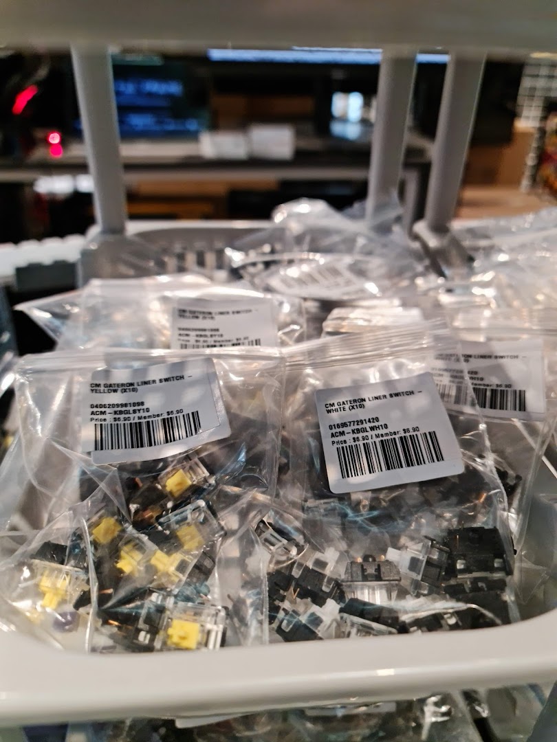 Close-up of bagged Gateron mechanical keyboard switches in yellow and white, displayed for sale.
