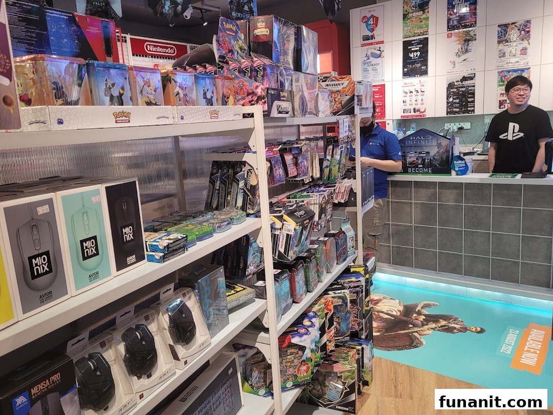 Interior view of GameMartz Funan Mall, showcasing shelves filled with gaming accessories, trading cards, and staff at the counter.