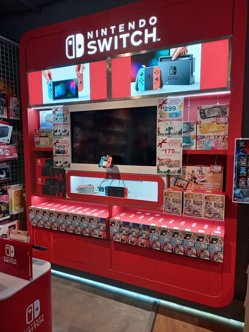 A vibrant red Nintendo Switch display stand showcasing consoles, games, and accessories inside the shop.