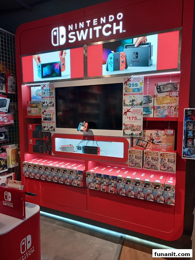 A vibrant red Nintendo Switch display stand showcasing consoles, games, and accessories inside the shop.