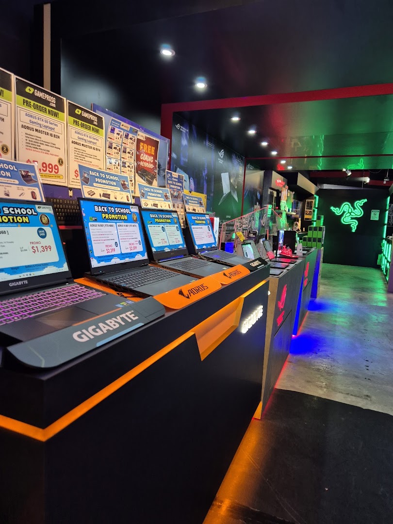 An interior view of GAMEPROSG, showcasing gaming laptops, accessories, and promotional displays.