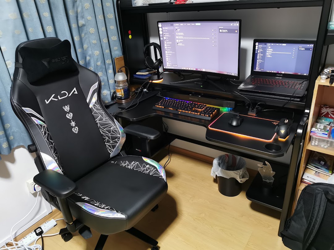 A high-performance gaming chair and a complete gaming setup with monitor, laptop, and peripherals.