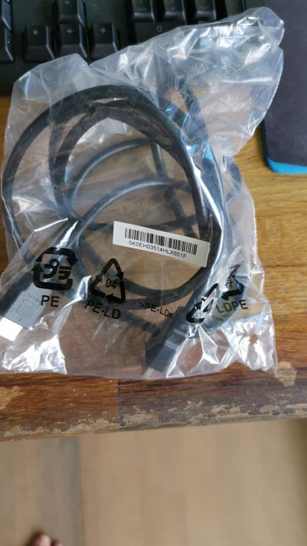 A black cable, likely for gaming or computer use, packaged in a clear plastic bag with a barcode.