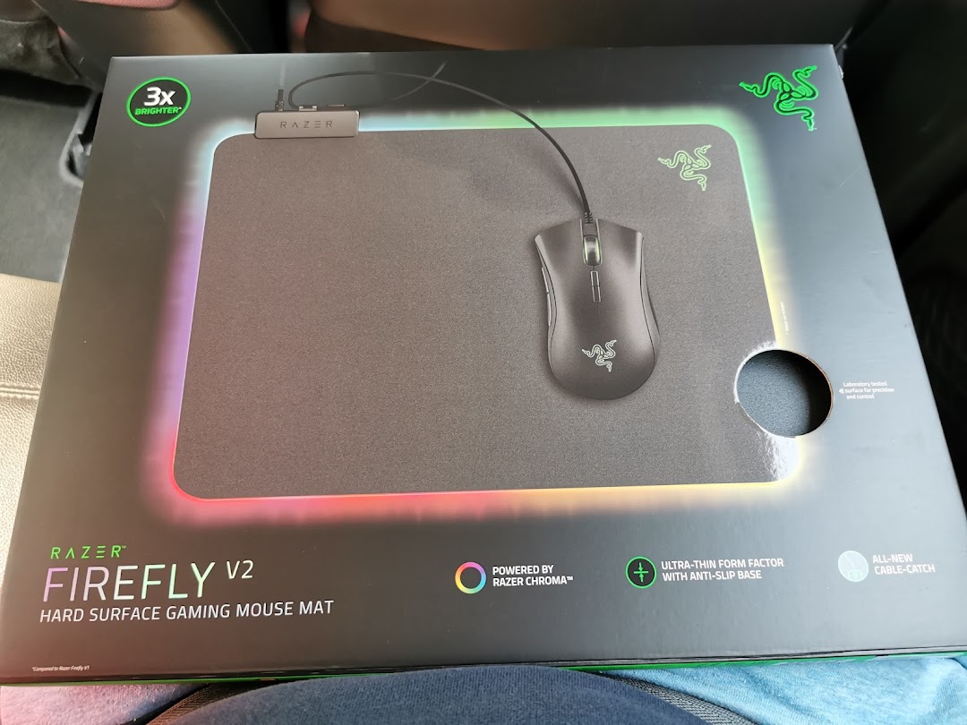 A Razer Firefly V2 hard surface gaming mouse mat in its product packaging, showcasing its features.