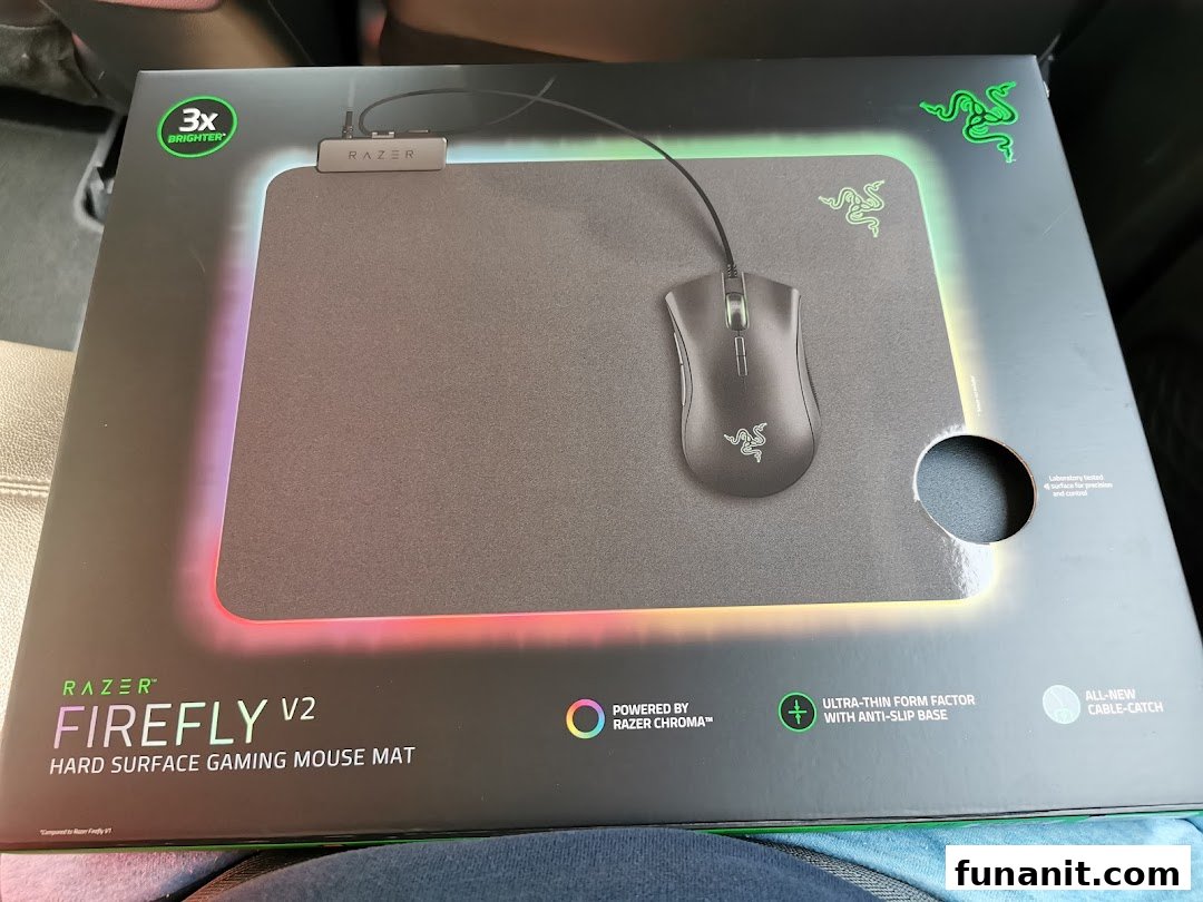 A Razer Firefly V2 hard surface gaming mouse mat in its product packaging, showcasing its features.